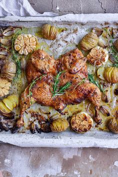 a pan filled with chicken, potatoes and herbs