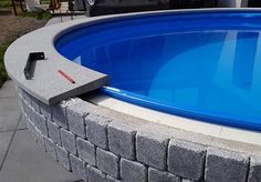 an empty swimming pool with a hammer sticking out of the bottom and a brick wall around it