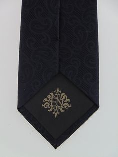 "Mens black on black 100% silk necktie. Available as a extra long tie. Handmade from 100% silk, this special collection features a .75\" Eds Neckties logo at the bottom right front corner of every tie and a larger logo located on the tipping (Back of the tie). The label features the collection name (Nathaniel Alexandria) Named after my son Nathaniel and my daughter Alexandria. Expertly hand-made from 100% silk you can select your length from 57\" to 63\" (Great for taller Men). Width is standard Elegant Formal Ties For Father's Day, Black Formal Ties For Father's Day, Black Fitted Suit And Tie Accessories For Father's Day, Elegant Ties For Black Tie Events And Father's Day, Elegant Black Tie For Father's Day, Elegant Black Neckwear With Inside Ties, Designer Ties For Black Tie Events, Luxury Ties For Black Tie Events, Silk Mark Certified Ties For Business