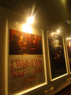 three movie posters are hanging on the wall in front of a window with light coming through them