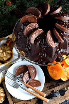 a cake with chocolate frosting and sliced oranges next to it on a plate