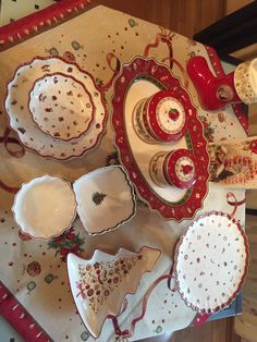 a table topped with lots of dishes covered in red and white cloth on top of a wooden table