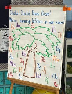 a child's drawing of a palm tree on a white board with letters and numbers