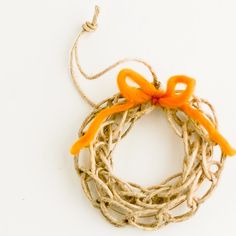 an orange bow is tied on top of some jute twine and sits on a white surface