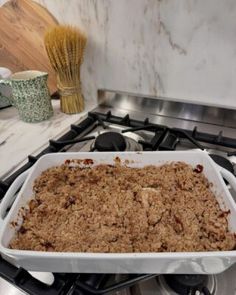 a casserole dish is sitting on the stove with oatmeal crumbs in it