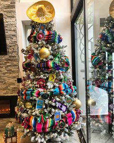 a brightly colored christmas tree with ribbons and ornaments