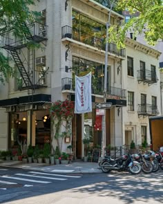 several motorcycles are parked in front of a building with balconies on the second floor