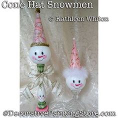 two snowmen with hats and bows on their heads