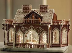 a gingerbread house is lit up with christmas lights