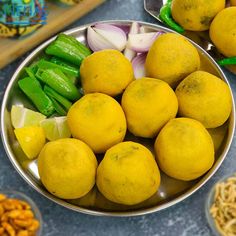 there are many different types of food in the bowl on the table, including lemons and snap peas