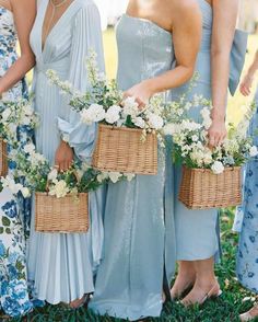 bridesmaids in blue dresses holding baskets with flowers