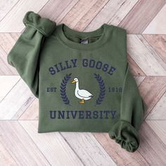 Silly Goose University Crewneck Sweatshirt,Unisex Silly Goose University Shirt,Funny Men's Sweatshirt,Funny Gift for Guys,Funny Goose Tshirt ---------- Ordering Your Custom Design T-shirt: Step by Step ---------- 1. Select your preferred t-shirt color. 2. Specify your desired size. 3. Pick the color for both your design and text. 4. Ensure that each step of your order is accurately completed. M A T E R I A L S → Our solid color options such as White and Black consist of 100% Cotton. → The Heathered Colors are a blend of cotton and polyester, ensuring a luxuriously soft feel. → Crafted as Short Sleeve Crew-Neck Unisex T-Shirts. → Composed of soft, high-quality Sueded Jersey fabric. → Pre-shrunk for lasting fit. → Taped shoulder-to-shoulder for enhanced durability. → Tear away label for adde Cheap Funny Print Crew Neck T-shirt, Cheap Funny Print Sweatshirt For Fall, Cheap Fall Sweatshirt With Funny Print, Cheap College Tops With Funny Text, Cheap Long Sleeve Sweatshirt With Funny Text, Cheap Funny Sweatshirt For Streetwear, Cheap Crew Neck Sweatshirt With Funny Text, Cheap Fall Sweatshirt With Funny Text, Cheap Funny Text Tops For College