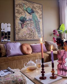 a living room filled with furniture and a painting on the wall above it's coffee table