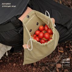 a person holding a bag full of tomatoes in it's hands and the bottom half of their pants is open