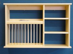 a wooden shelf with white bars on it against a blue wall in a room that appears to be used as a storage unit