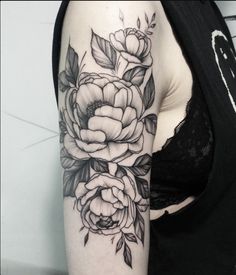 a black and white flower tattoo on the arm