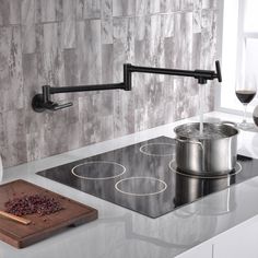 a kitchen counter with a pot on the stove and a cutting board next to it