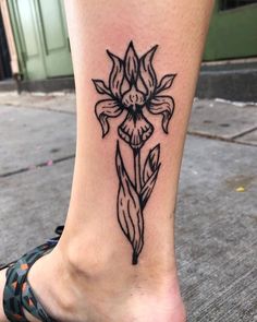 a woman's foot with a flower tattoo on the side of her leg,