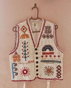 an embroidered vest hanging on a wall