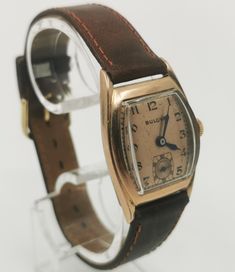 Rare 1940s original BULOVA CURVEX TANK with brand new brown saddle leather strap and with a very well preserved Curvex glass, with sought-after, salmon-colored original dial with black, Arabic indexes and original, blued steel pointers. Original legendary BULOVA caliber 10BC with 15 jewels, watch runs perfectly for it's age. Worth collecting, original timeless classic in good condition! Vintage Brown Watch With Rectangular Dial, Vintage Brown Formal Watches, Antique Brown Analog Watch, Vintage Brown Leather Watches, Vintage Formal Watch With Leather Strap, Vintage Brown Watch With Leather Strap, Vintage Brown Watches With Leather Strap, Vintage Leather Watches For Business, Brown Retro Formal Watch