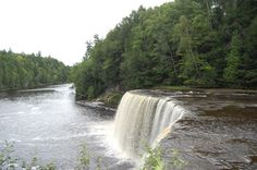 there is a waterfall in the middle of the river with water coming out of it