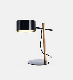 a table lamp with a black shade on the top and a wooden stick attached to it