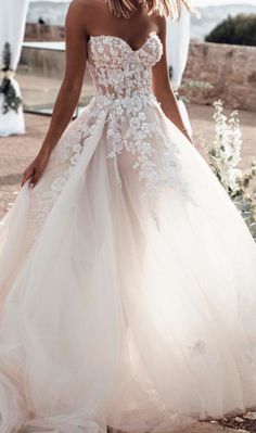 a woman in a wedding dress standing outside