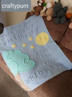 a crocheted baby blanket on a couch with stuffed animals and teddy bears in the background