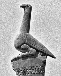 a black and white photo of a bird statue