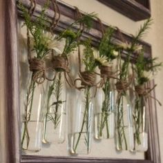 flowers are in glass vases tied to the wall with twine and burlocks