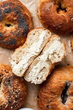 freshly baked bagels with poppy seed crusts on parchment paper, ready to be eaten