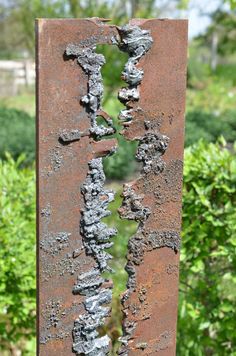 an old rusted metal object in the middle of some bushes