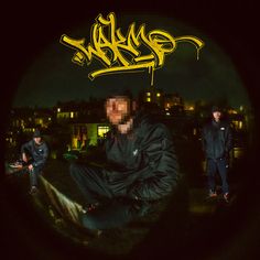 two young men sitting on top of a roof at night with the word graffiti written over them