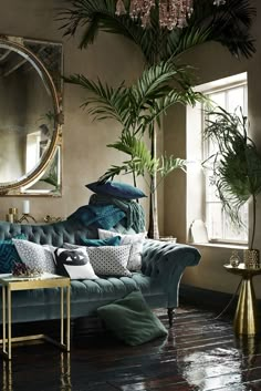 a living room filled with furniture and a large mirror on the wall next to a potted plant