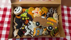 a box full of decorated halloween cookies on a table