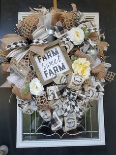 a wreath that says farm sweet farm with flowers on the front and side of it