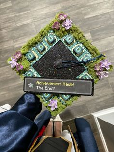 a graduation cap that has been decorated with flowers and the words achievement made in the end?