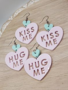 "These \"Hug Me\" and \"Kiss Me\" heart earrings are such a fun accessory for Valentine's Day! The top (smaller) heart is mint green acrylic and the bottom (larger) heart is light pink acrylic with your choice of \"Hug Me\" or \"Kiss Me\" cut out of the larger heart.  The dimensions are as follows: Drop Length (including earring hook): 2.75\" Length (not including earring hook): 2\" Width: 1.9\" The earring hardware is hypoallergenic stainless steel.  Note: This listing is for q pair of earrings. Please indicate the design of your choice by selecting it from the drop down list." Personalized Earrings For Valentine's Day, Cute Dangle Earrings For Valentine's Day, Personalized Heart Earrings For Valentine's Day, Cute Heart Earrings For Valentine's Day, Cute Heart Charm Earrings For Valentine's Day, Cute Heart-shaped Earrings For Valentine's Day, Cute Drop Earrings For Valentine's Day, Personalized Heart Earrings For Birthday, Heart-shaped Earrings For Valentine's Day Birthday