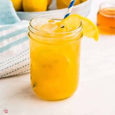 a mason jar filled with lemonade and topped with a blue striped straw