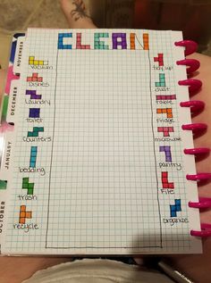 a person holding a notepad with colored squares on it and writing the word clean