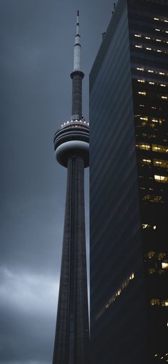 a tall building with a sky scraper at the top and two other buildings in the background