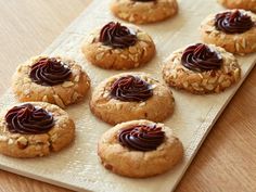 cookies with chocolate frosting and nuts on a tray