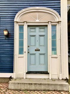 a blue and white house with an arched door