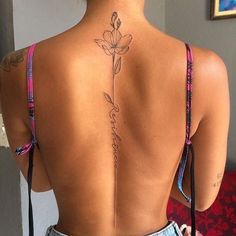 the back of a woman's body with tattoos on her upper and lower back