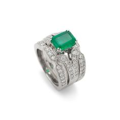 Gender: Ladies    Metal Type: 18K White Gold    Size: 5.5    Width: 2.85 mm    Ring measures approximately in width: 2.85 mm    Jacket measures in width: 8.50 mm    Weight: 15.69 grams    18K White Gold Diamond and Emerald Cocktail Ring with a soft-square shank. The ring is a size 5.5. The ring weighs a total of 15.69 grams. Engraved with "18K".    In Excellent Condition.    4-Prong Set in 18 Karat White Gold with:    One (1) natural, emerald-cut, step cut, emerald:    Species: Natural Beryl  Variety: Natural Emerald  Measurements: 8.66mm x 6.44mm x 3.83mm in depth.  Estimated Weight: 1.57 ct.  Cut Style: Crown Step Cut  Cut Style: Pavilion Step Cut  Color(s): Strongly Green  Clarity: Slightly Included (Type III)  Pavé set in 18 Karat White Gold with:    Fifty-four (54) round brilliant cut Elegant Stackable Emerald Cut Rings, Elegant Stackable Rings With Emerald Cut, Formal Stackable Emerald Cut Diamond Ring, White Gold Emerald Cut Stackable Rings, Stackable Emerald Cut White Gold Rings, Formal Emerald Cut Gemstone Stackable Rings, Luxury Gemstone Stackable Rings For Formal Occasions, Formal Stackable Platinum Rings, Luxury Stackable Emerald Ring