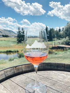 a wine glass sitting on top of a wooden barrel