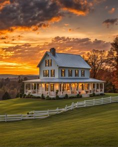 a large white house sitting on top of a lush green field under a cloudy sky