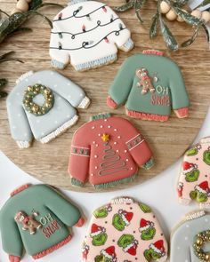 decorated cookies on a wooden platter with christmas sweaters and mittens in the background