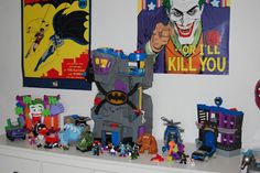 a bunch of toys that are on top of a shelf in a room with posters