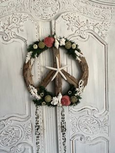 a peace sign made out of wood with flowers and chains hanging on the front door